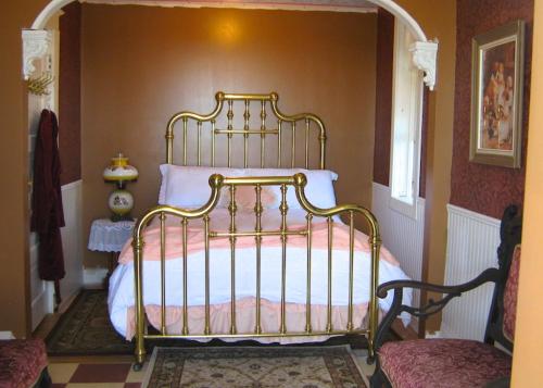 Un dormitorio con una cama dorada en una habitación en Wakamow Heights Bed and Breakfast, en Moose Jaw