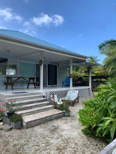 une maison avec une terrasse couverte dotée d'un banc et d'une table dans l'établissement LE FARE BLEU Tiputa Rangiroa, à Tiputa