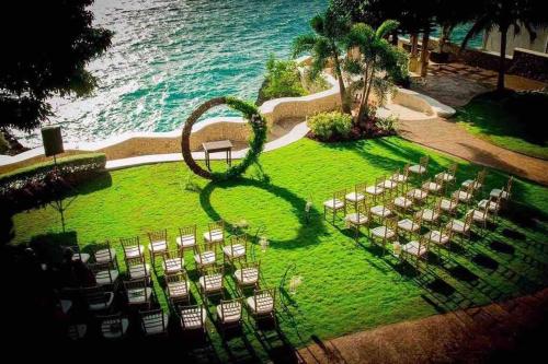 an image of a wedding ceremony on the lawn near the ocean at Villa Gilgal in Kings Pen
