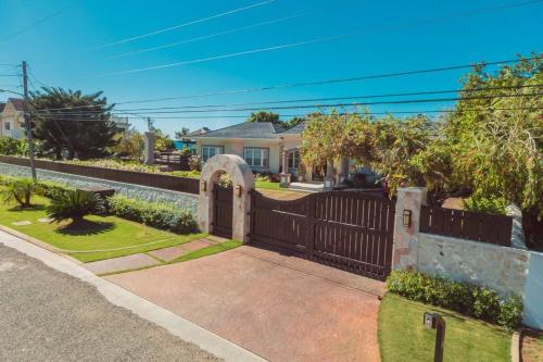 a house with a wooden fence and a gate at Villa Gilgal in Kings Pen