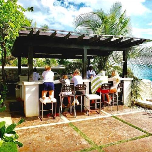 a group of people sitting at a bar at Villa Gilgal in Kings Pen