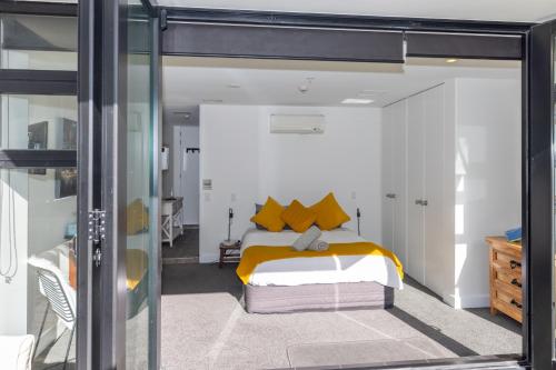 una camera da letto con letto e cuscini gialli di Eleven_at_Mauao a Mount Maunganui