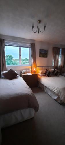 Wigton的住宿－The White Heather Hotel，酒店客房设有两张床和窗户。