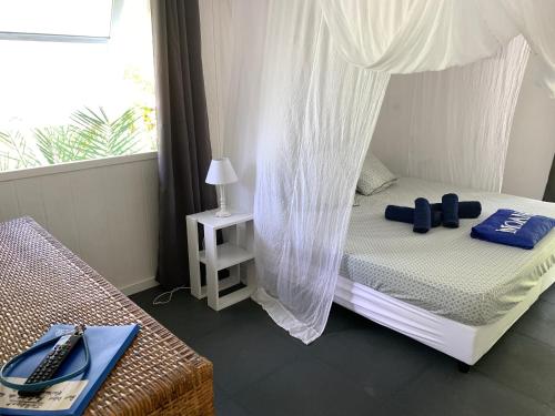 a bedroom with a bed with a canopy at LE FARE BLEU Tiputa Rangiroa in Tiputa