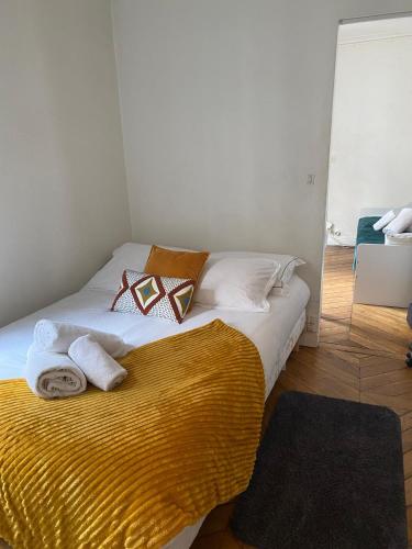 une chambre avec un lit avec des serviettes dessus dans l'établissement Appartement bien placé, à Paris