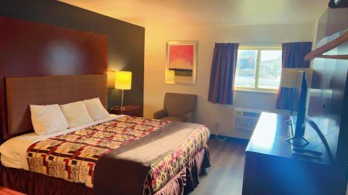 a hotel room with a bed and a window at Rodeway Inn Rifle in Rifle