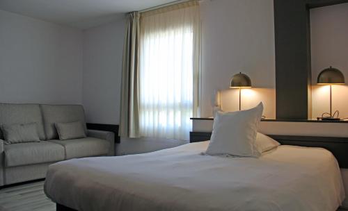 a hotel room with a bed and a couch at Beau Rivage in Charavines