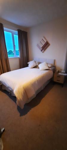 a bedroom with a large white bed with a window at The White Heather Hotel in Wigton