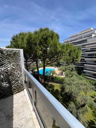 d'un balcon avec vue sur la piscine et les arbres. dans l'établissement Beautiful studio in Juan Les Pins, à Antibes