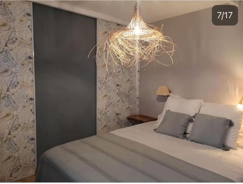 une chambre avec un grand lit et un lustre dans l'établissement Villa de charme avec piscine en plein cœur du Var, à Rocbaron