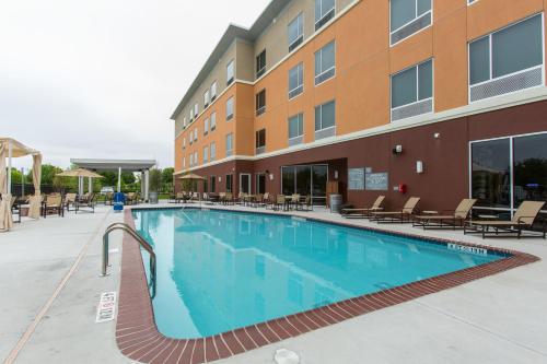 a large swimming pool in front of a building at Cambria Hotel Plano - Frisco in Plano
