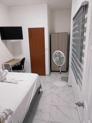 a bedroom with a bed and a fan in a room at Hotel Orduz Centro Histórico de Cali in Cali