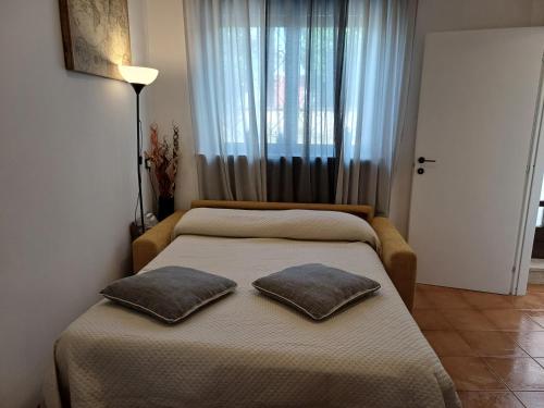 a bedroom with two beds with pillows in front of a window at Locazione turistica Ani in Novara