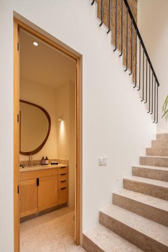 a staircase leading to a bathroom with a sink and a mirror at HOLT Parque Juarez Privada Stunning 5BR Villa in San Miguel de Allende