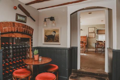 een kamer met een tafel en stoelen en een wijnkelder bij The Butterleigh Inn in Cullompton