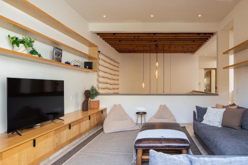 a living room with a couch and a flat screen tv at HOLT Parque Juarez Privada Stunning 5BR Villa in San Miguel de Allende
