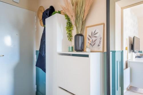une armoire blanche avec des plantes dans une pièce dans l'établissement Studio Luxe Paris, à Paris
