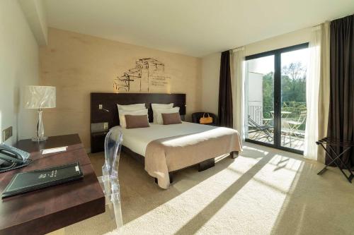 a bedroom with a large bed and a table and a bed sidx sidx at Best Western Plus Villa Saint Antoine Hotel & Spa in Clisson