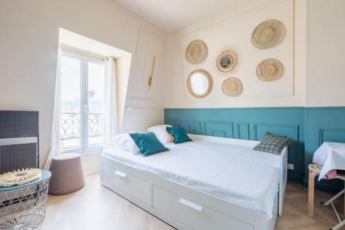 - une chambre avec un lit bleu et blanc dans l'établissement Studio Luxe Paris, à Paris