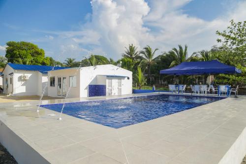 a swimming pool in front of a villa at Cabaña Palma Azul in Coveñas