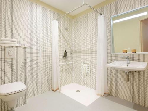 La salle de bains est pourvue d'une douche, de toilettes et d'un lavabo. dans l'établissement ibis budget Antony Massy rénové 2024, à Antony