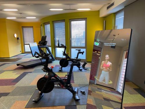 a gym with treadmills and exercise bikes in a room at Median Hotel Hannover Lehrte in Lehrte