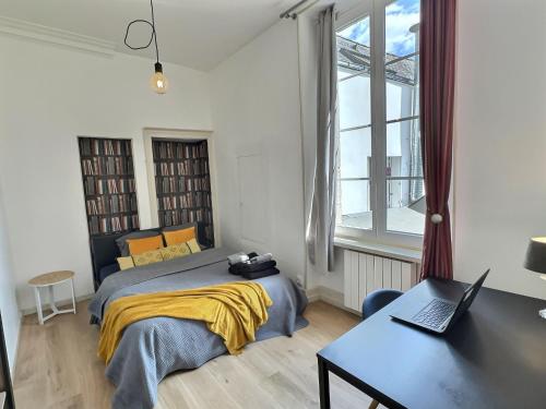 une chambre avec un lit et un bureau avec un ordinateur portable dans l'établissement Hypercentre Grand T4 équipé - Proximité Puy Du Fou, à Cholet