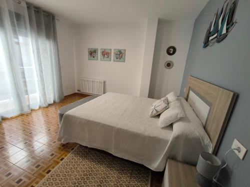 a bedroom with a large bed and a wooden floor at Casa Marga O Grove in O Grove