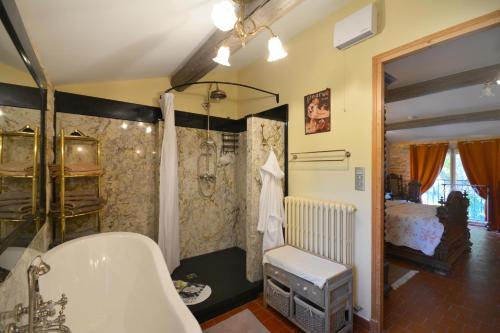 La salle de bains est pourvue d'une baignoire et d'une douche. dans l'établissement Le Coin Retro, au Thor