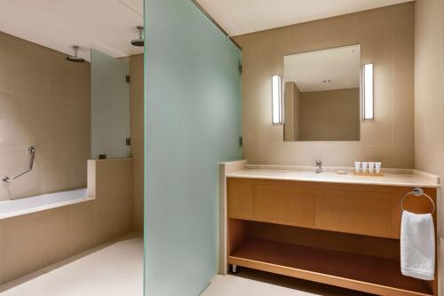 a bathroom with a sink and a mirror at Levatio Suites Muscat, a member of Radisson Individuals in Muscat