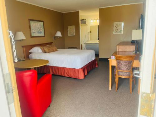 ein Hotelzimmer mit einem Bett, einem Tisch und Stühlen in der Unterkunft Travelodge by Wyndham Moose Jaw in Moose Jaw