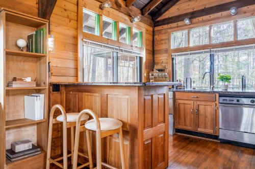 a kitchen with wooden cabinets and a counter with stools at Stunning Couples Retreat Lodge in Milford