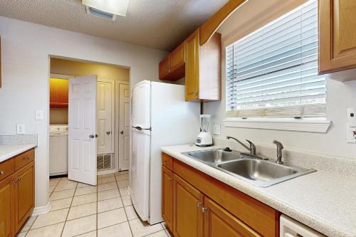 La cuisine est équipée d'un réfrigérateur blanc et d'un évier. dans l'établissement Sugar Beach D17, à Navarre