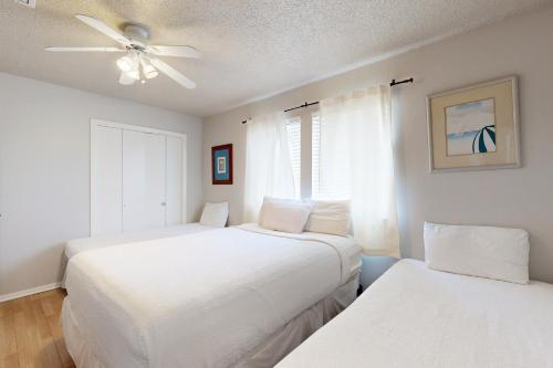 1 dormitorio con 2 camas y ventilador de techo en Sugar Beach D17, en Navarre