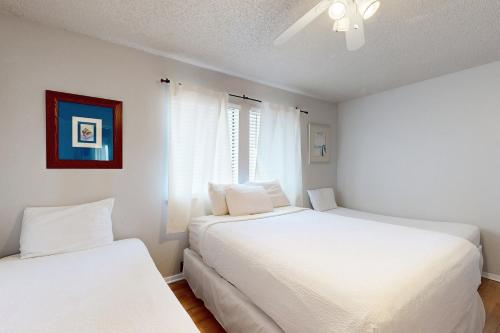 two white beds in a room with a window at Sugar Beach D17 in Navarre