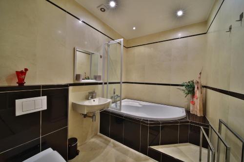 un baño con lavabo y bañera en DiamondHouse vila & wellness, en Kolín