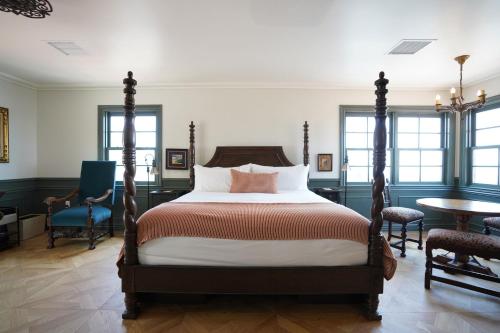 1 dormitorio con 1 cama, mesa y sillas en El Caminante Bar & Bungalows, en Capistrano Beach