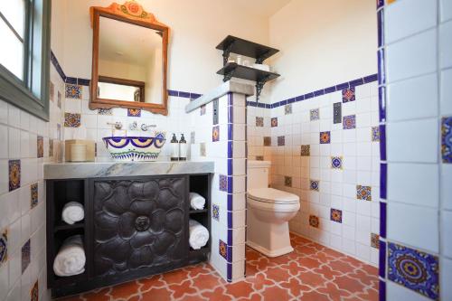 uma casa de banho com um WC e um espelho. em El Caminante Bar & Bungalows em Capistrano Beach