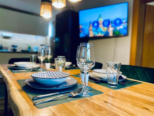 einem Holztisch mit Tellern, Schalen und Gläsern darauf in der Unterkunft Belisima Apartments I Ferienwohnungen Fischbachau - Breitenstein I Region Schliersee I Historisch & Cozy mit Bergblick I 2 Schlafzimmer I Waschmaschine I Parkplatz I Nähe Supermarkt in Fischbachau