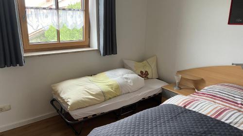 a small room with a bed and a window at Lisa's Ferienwohnung in Obing