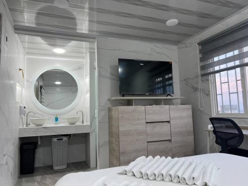 a bedroom with a bed and a sink and a mirror at Hotel Orduz Centro Histórico de Cali in Cali