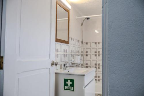 een badkamer met een wastafel en een spiegel bij Casa da Avó Couta in Angra do Heroísmo