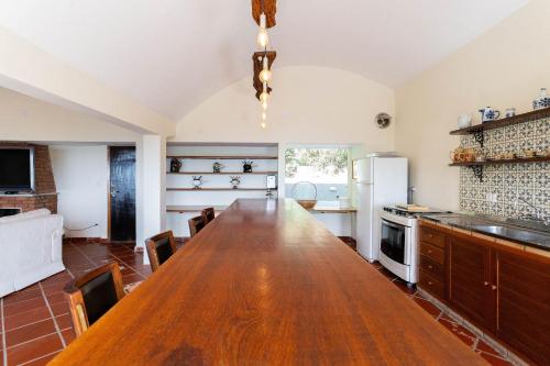 a kitchen with a large wooden table in a room at Pousada Cantareira - Suítes na Serra da Cantareira in Mairiporã