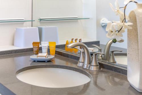 a bathroom counter with a sink and a mirror at Waikiki Beach Ocean View King Bed & Free Parking in Honolulu