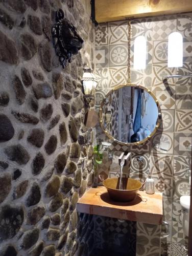 y baño con lavabo y espejo en una pared de piedra. en Alborada Bernal, en Bernal
