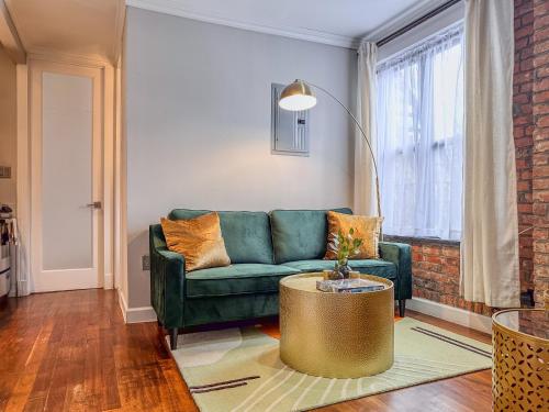 a living room with a green couch and a table at New York Suite Upper East Side - Manhattan in New York