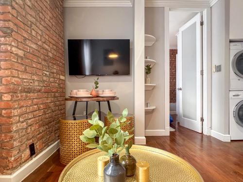 a living room with a brick wall and a table at New York Suite Upper East Side - Manhattan in New York