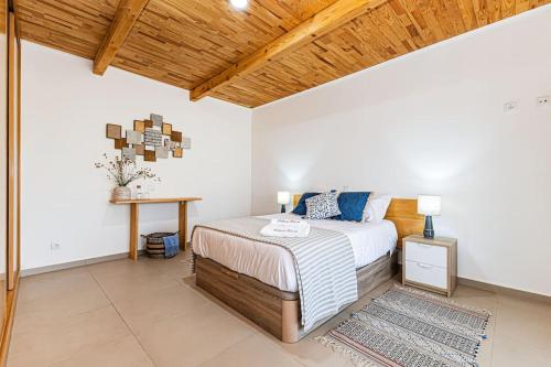 a bedroom with a bed and a wooden ceiling at Salicos House - Lagoa - Benagil in Lagoa