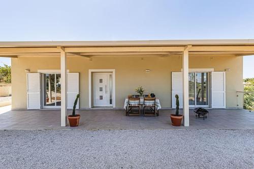a house with a patio with a table and chairs at Salicos House - Lagoa - Benagil in Lagoa