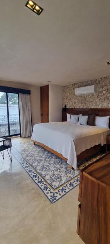 a bedroom with a large bed and a large window at Casa Boutique Pashá in Mérida